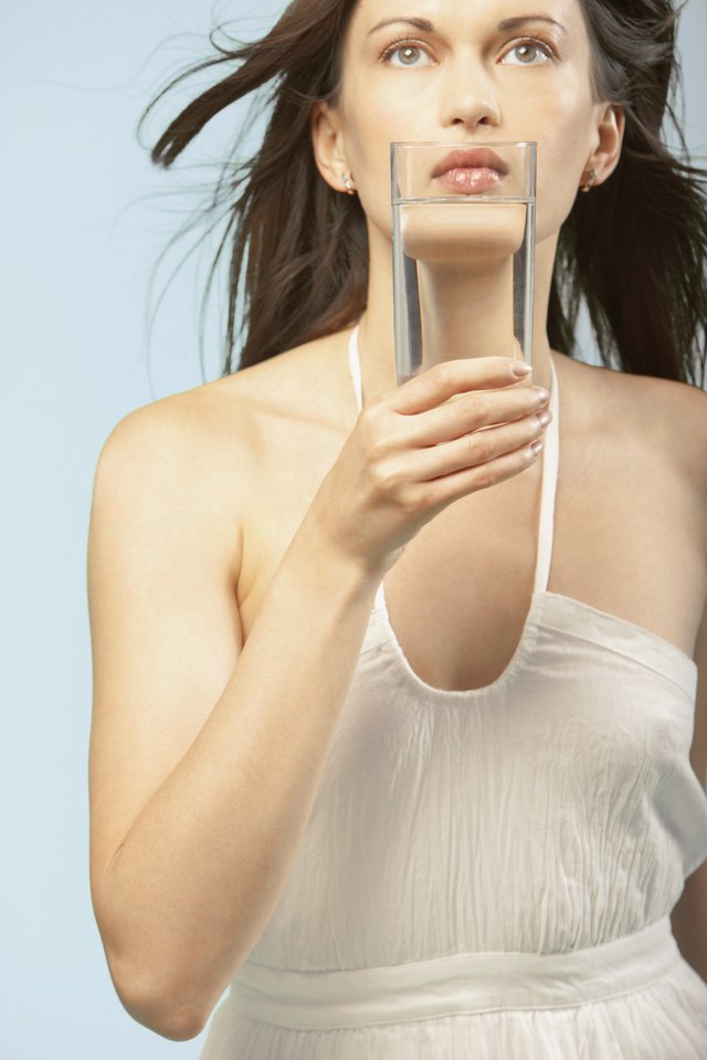 Portrait of woman holding glass of water to mouth