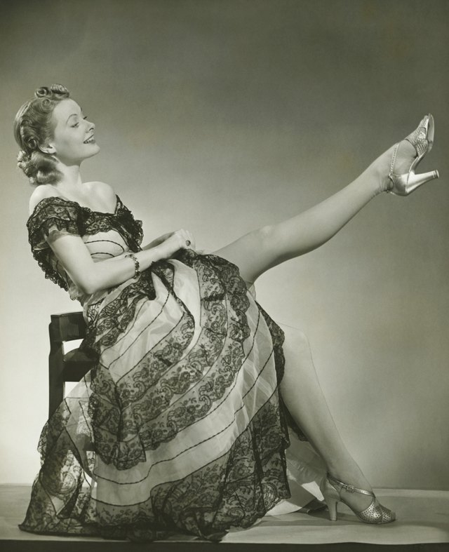 Glamorous woman in evening gown showing leg, portrait, (B&W)