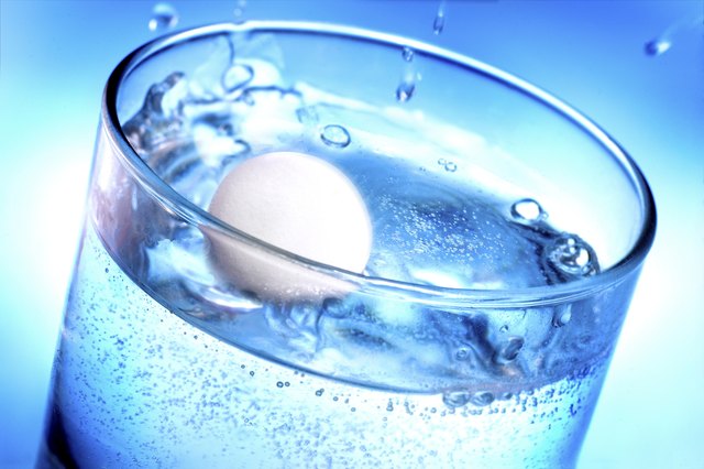 Medicine pill tablet splashing into glass