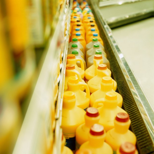 Rows of plastic containers of orange juice in supermarket