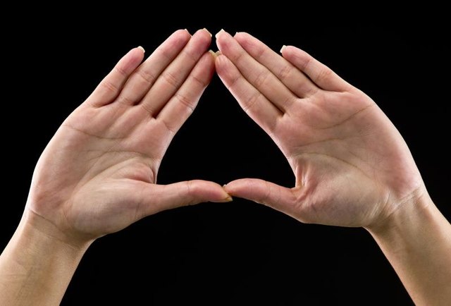 Real people, caucasian woman's hands on black background forming a triangle. In some countries this is a feminist hand sign (this picture have been shot with a Hasselblad HD3 II 31 megapixels)