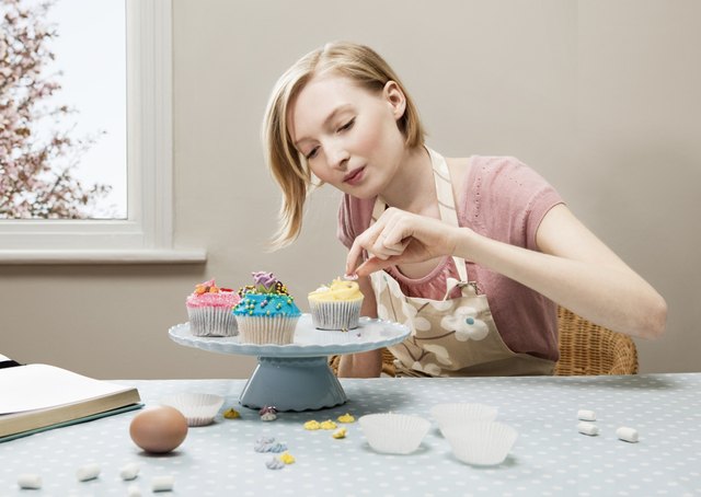 woman decorating cupcakes.