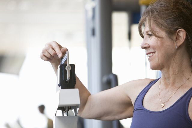 senior woman weighing herself at a gym