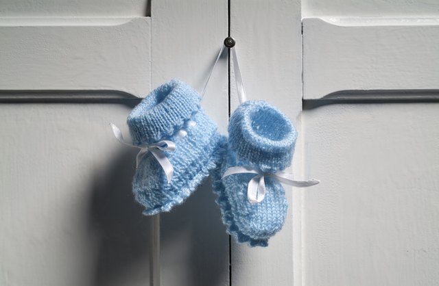 Blue Baby Booties hanging on white door