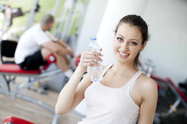 Girl drinking water in the gym