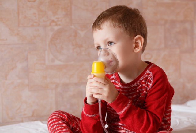 Sick little boy makes inhalation mask for breathing at home