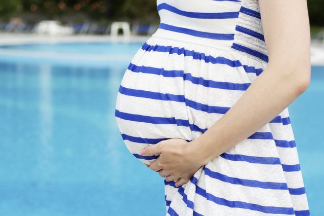 Beautiful pregnant woman relaxing in the park