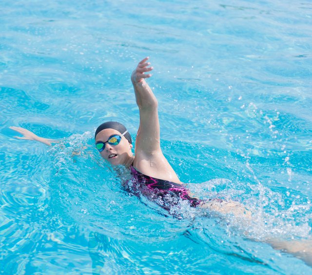 Woman in goggles swimming front crawl style