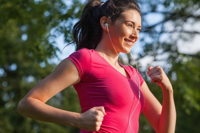Cheerful young woman jogging in a park