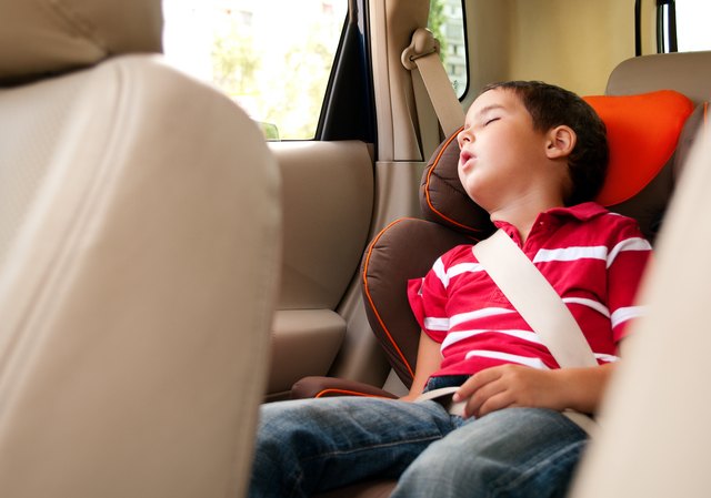 Litle boy sleeps in safe chair car