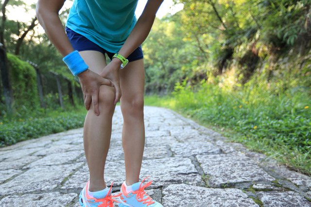woman runner hold her sports injured knee
