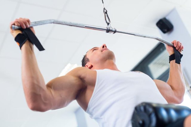 Man doing bodybuilding sport by exercising lifting dumbbells in fitness club or gym