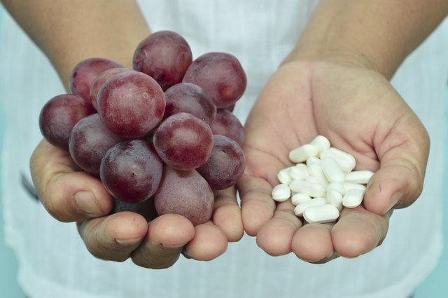 hand holding a grape and drug