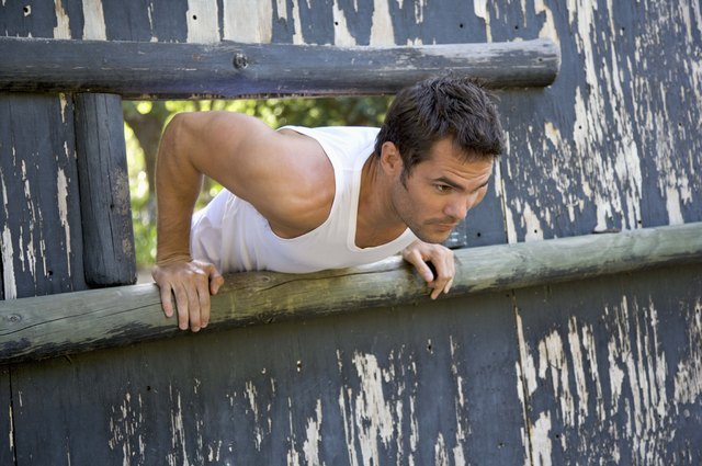 Man climbing through obstacle course