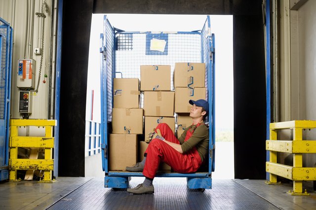Worker sitting on loading dock with boxes