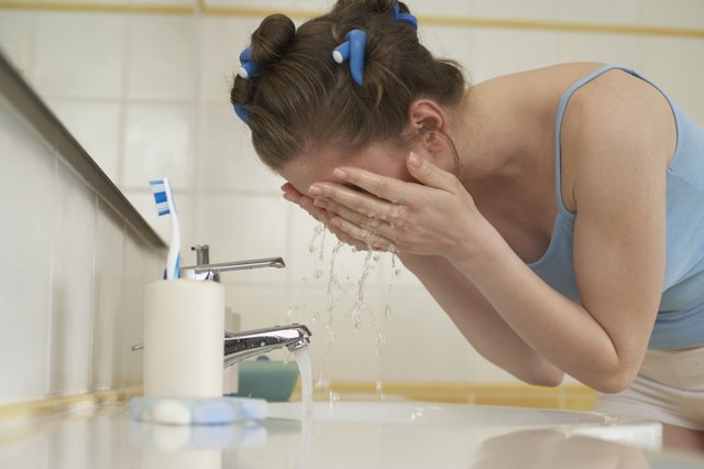 Woman washing her face in bathroom