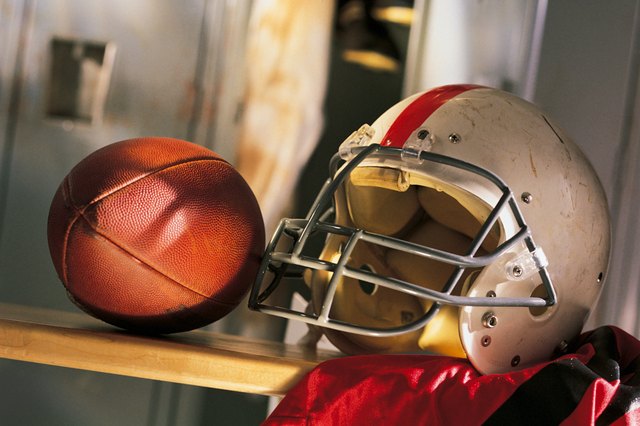 Football and helmet with jersey on locker room bench