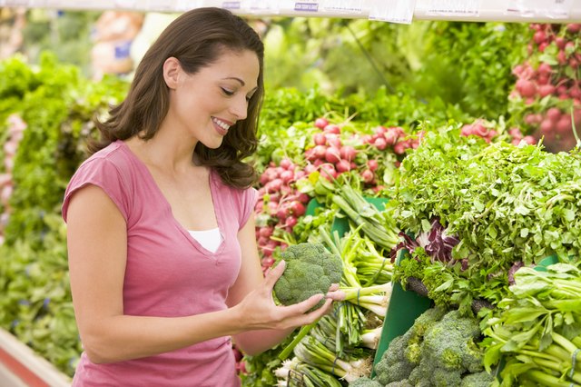 Woman shopping for broccoli at a grocery store