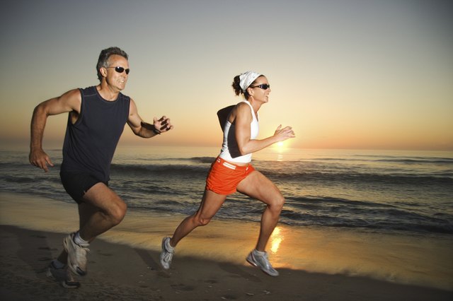 Couple running on beach at sunrise