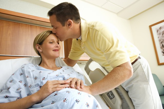 Husband kissing pregnant wife in hospital