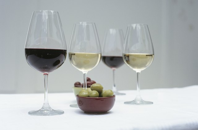 Glasses of wine and olives on table