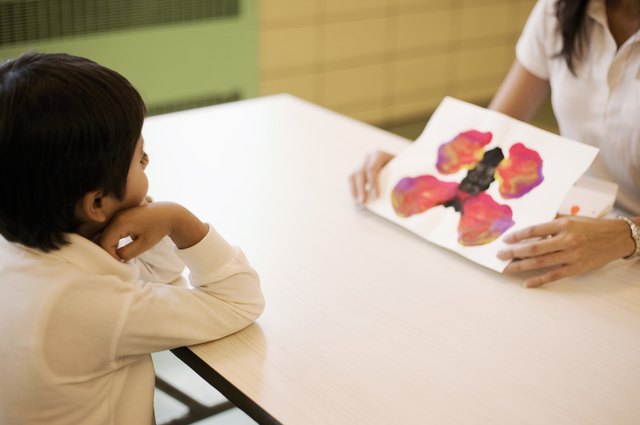 Teacher showing inkblot paintings to student