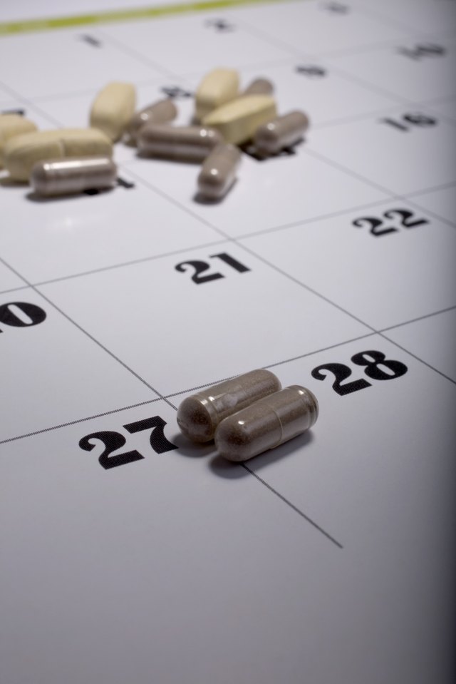 Pills scattered on a calendar page