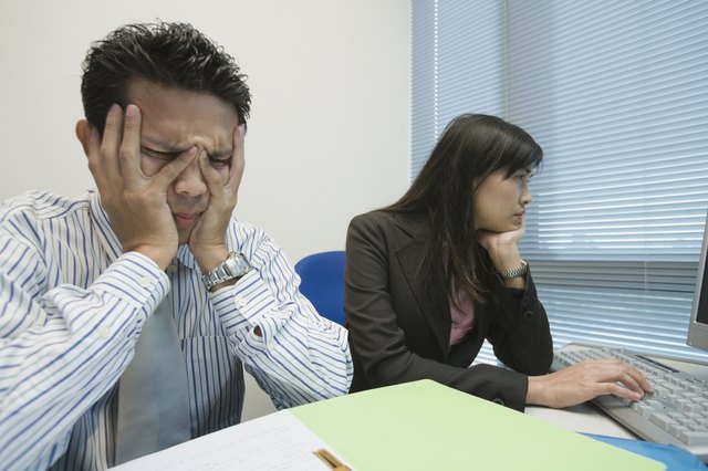 Frustrated Asian businessman at desk