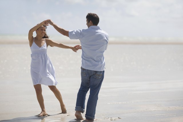 Hispanic couple dancing at beach