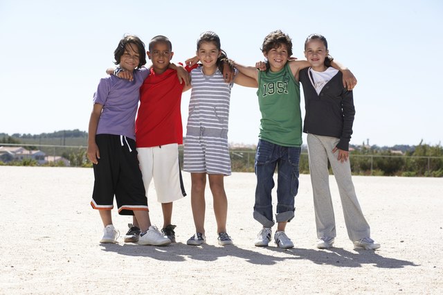 Group portrait of children (9-12) embracing outdoors