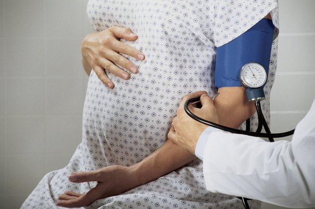 Doctor taking blood pressure from pregnant woman