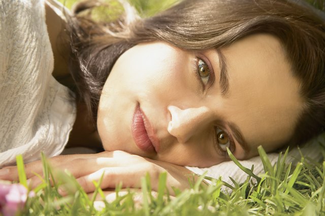 Young woman lying on the grass looking at camera