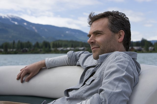 Mature man relaxing in inflatable raft on lake, close-up