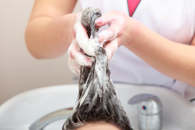 Hairstylist washing woman hair. Hairdressing beauty salon