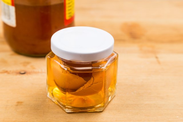 Jar containing soaked egg shell in apple cider vinegar