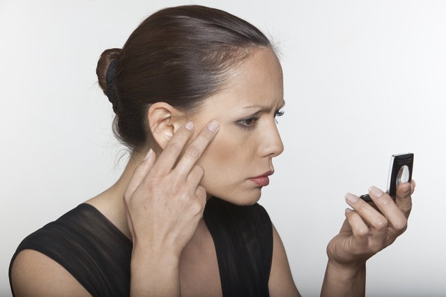 beautiful asian woman aging looking in the mirror