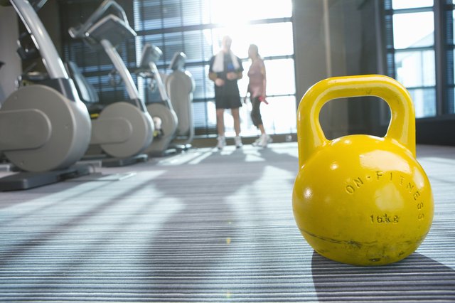 Yellow medicine ball on floor in health club with couple