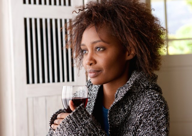 Beautiful african woman holding glass of wine