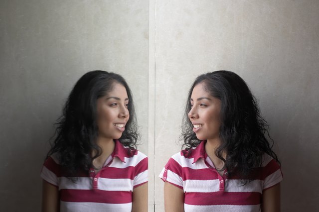 Side profile of a young woman looking at her reflection