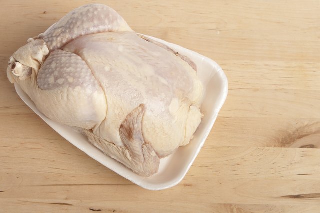 Frozen chicken on cutting board.