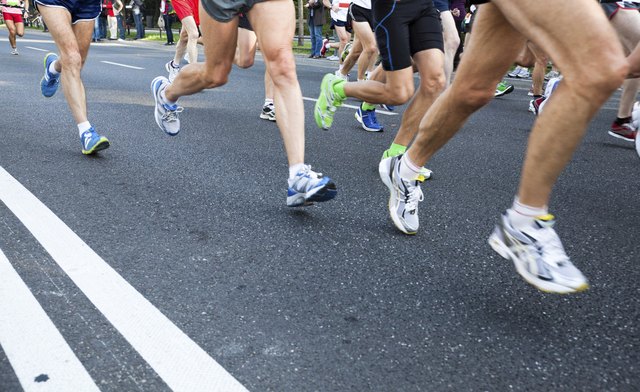 People running in city marathon on street