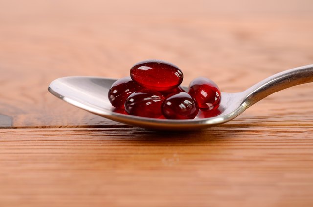 Red capsules on a spoon
