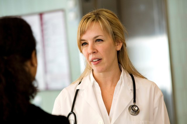 Female doctor talking to patient in hospital.