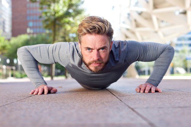 Fit man doing push ups outdoors