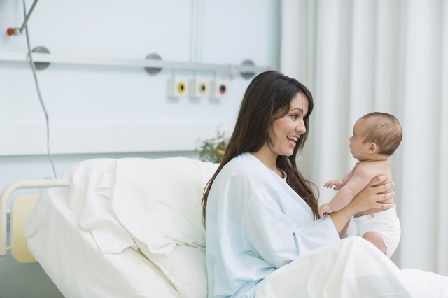Happy mother holding a baby boy in diaper