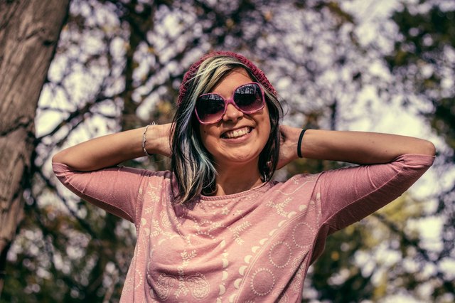 Young cute hipster woman with sunglasses and hat smiling
