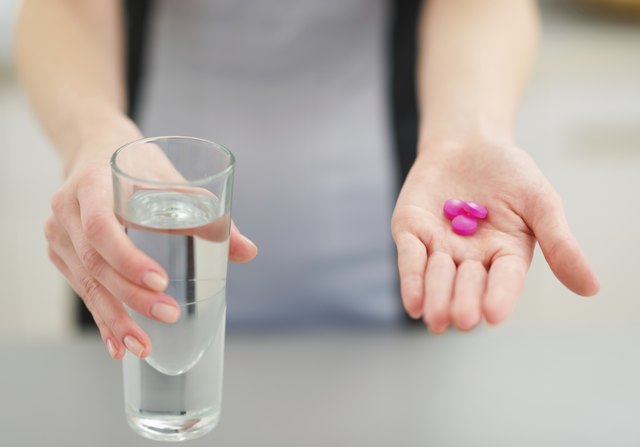Closeup on pills in hand of young housewife