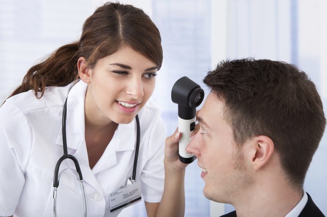 Doctor Examining Businessman With Dermoscope