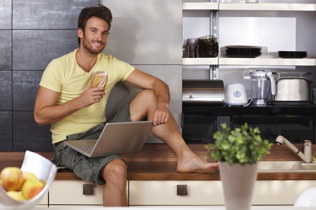 Handsome man with laptop in kitchen