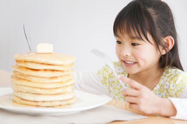 Girl about to enjoy a stack of pancakes